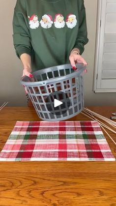 a woman holding a basket on top of a table next to knitting needles and scissors