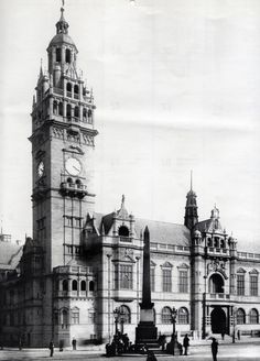 an old black and white photo of a large building with a clock on it's tower