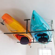 three kayaks are hanging from the ceiling