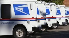 several mail trucks are lined up in a row