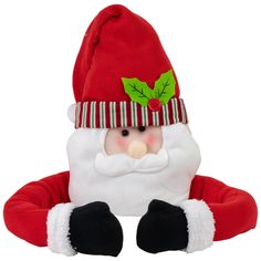 a red and white stuffed santa claus with green leaves on it's head sitting down