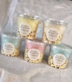 five plastic containers filled with different types of popcorn