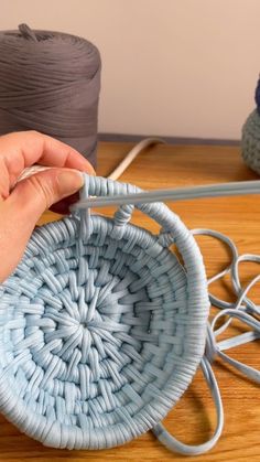 a person is knitting yarn on a table