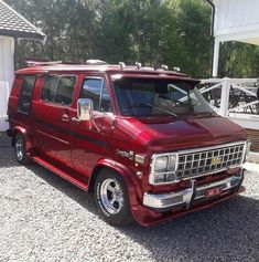 a red van parked in front of a white house