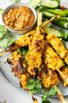 chicken skewers on a plate with dipping sauce