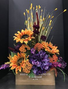 an arrangement of flowers in a wooden box on a table with the words feed & blooming co