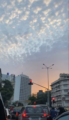 cars are stopped at a red light in the middle of an urban area with tall buildings