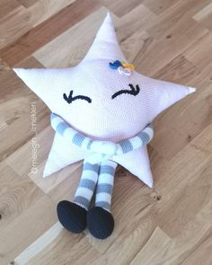 a white stuffed star laying on top of a wooden floor