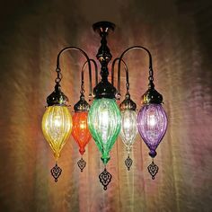 four colorful lights hanging from a ceiling fixture