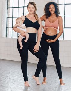 two women in sports bra tops and black leggings holding a baby