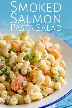 a white bowl filled with pasta salad on top of a blue table