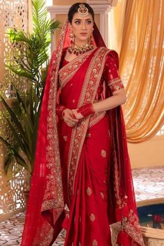 a woman in a red sari and gold jewelry