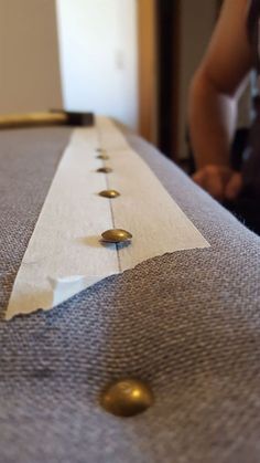 a close up of a piece of cloth with buttons on it and a person in the background