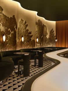 the interior of a restaurant with black and white checkered flooring, walls painted with trees