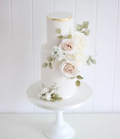 a white three tiered cake with flowers on it