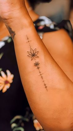 a woman's arm with a flower tattoo on it