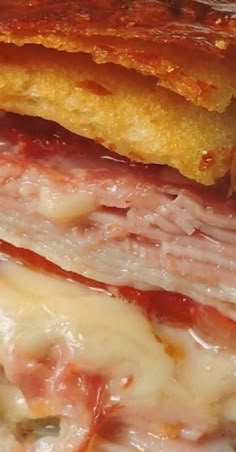 a close up of a sandwich with meat and cheese on it's crusts