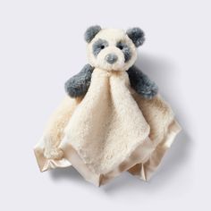 a teddy bear wrapped in a blanket on top of a white surface with grey trim