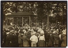 an old black and white photo of people standing in front of a gazebo