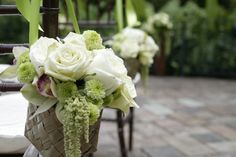 the flowers are arranged in baskets on the chairs for an outdoor wedding ceremony or reception