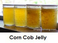 four jars filled with yellow liquid sitting on top of a window sill