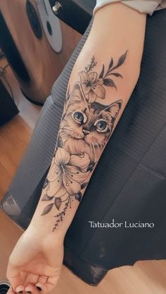 a woman's arm with a cat and flowers tattoo on the left side of her arm