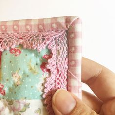 someone is stitching the edges of a miniature frame