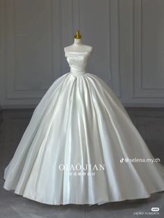 a white wedding dress on display in a room