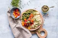 a bowl filled with rice and vegetables next to other food on top of a table