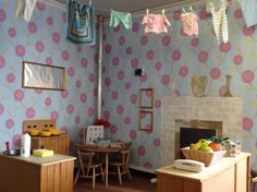 a living room filled with furniture and a fire place next to a wall covered in flowers