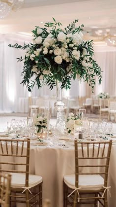 an elegant wedding reception with white flowers and greenery