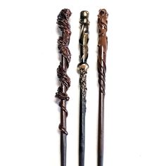 three old fashioned canes are lined up on the wall, one has a knoted handle