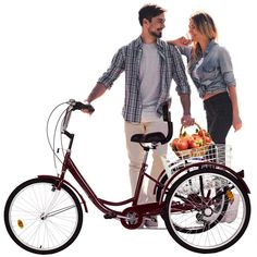 a man and woman standing next to each other with a basket on the back of a bike