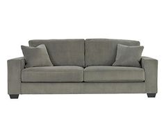 a gray couch with two pillows on it and one arm folded back to the side