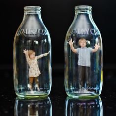 two glass jars with children's pictures on them, one is empty and the other has a doll in it