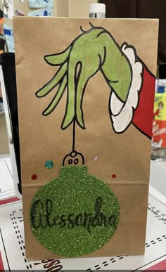 a paper bag with an image of a hand holding a christmas ornament