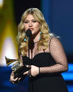 the singer is holding an award in her hand