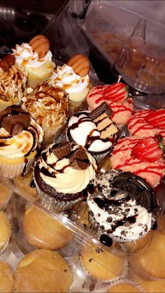 a tray filled with lots of different types of cupcakes and muffins