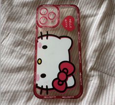 an iphone case with hello kitty on it sitting on top of a white bed sheet