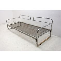 a metal couch sitting on top of a white floor