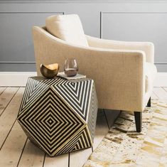 a living room with a chair, table and vases on the floor in front of it