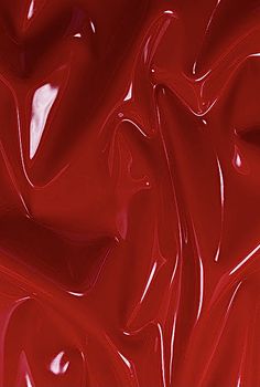 an image of red paint that looks like it has been swirled in different directions and colors