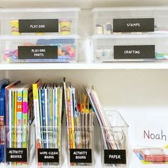 the shelves have clear bins with labels on them and plastic containers filled with school supplies