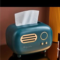 a blue toaster sitting on top of a table next to a box of tissues