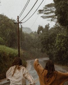 two women walking down the road in the rain