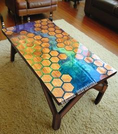 a coffee table made out of stained glass and wood with honeycombs on it