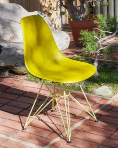 a yellow chair sitting on top of a brick floor