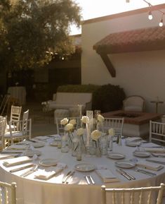 the table is set with white linens and silverware for an elegant wedding reception