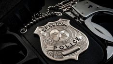 a metal police badge sitting on top of a black case next to a pair of glasses