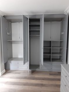 an empty closet with white cabinets and drawers